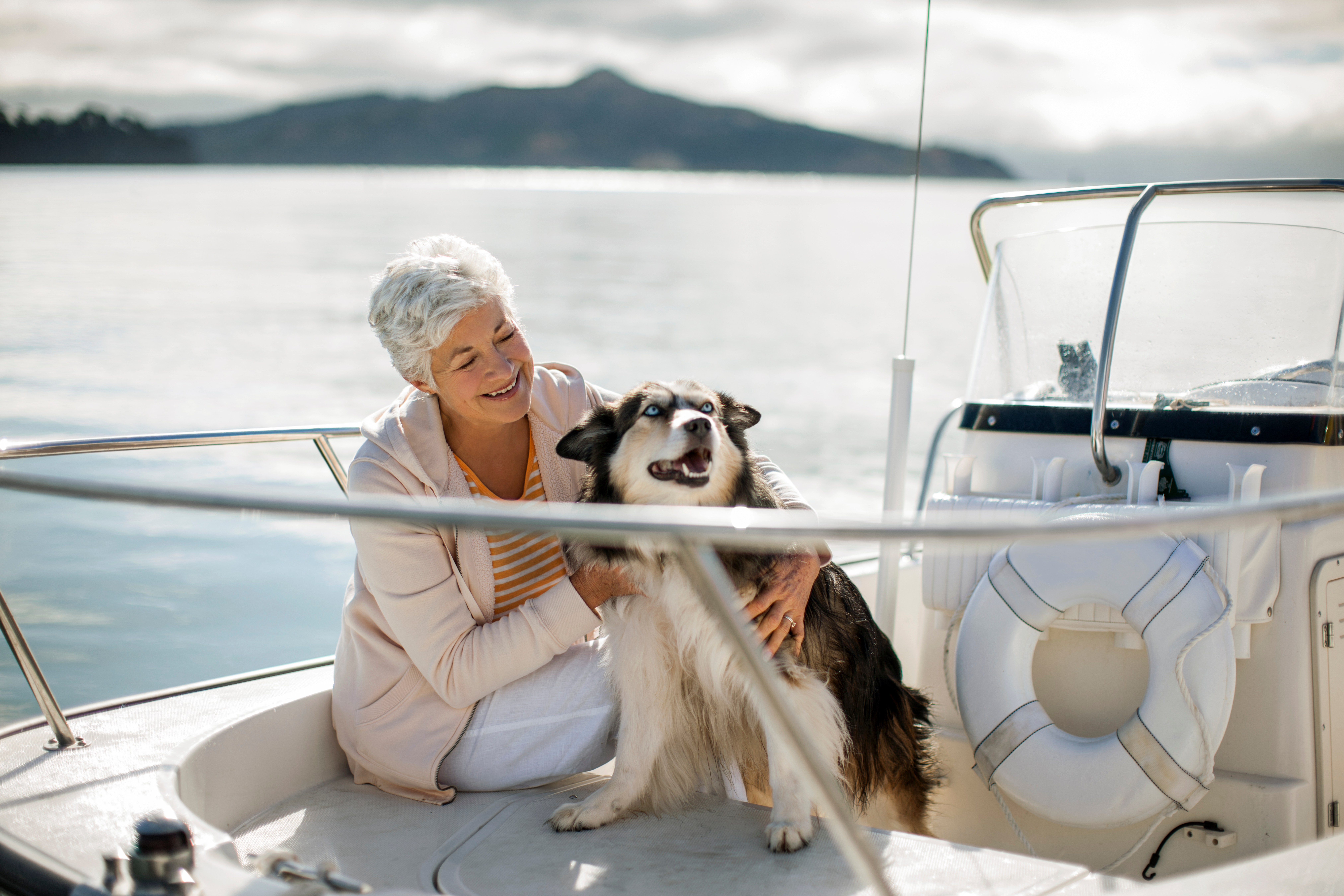 Woman and dog happy together on a boat 