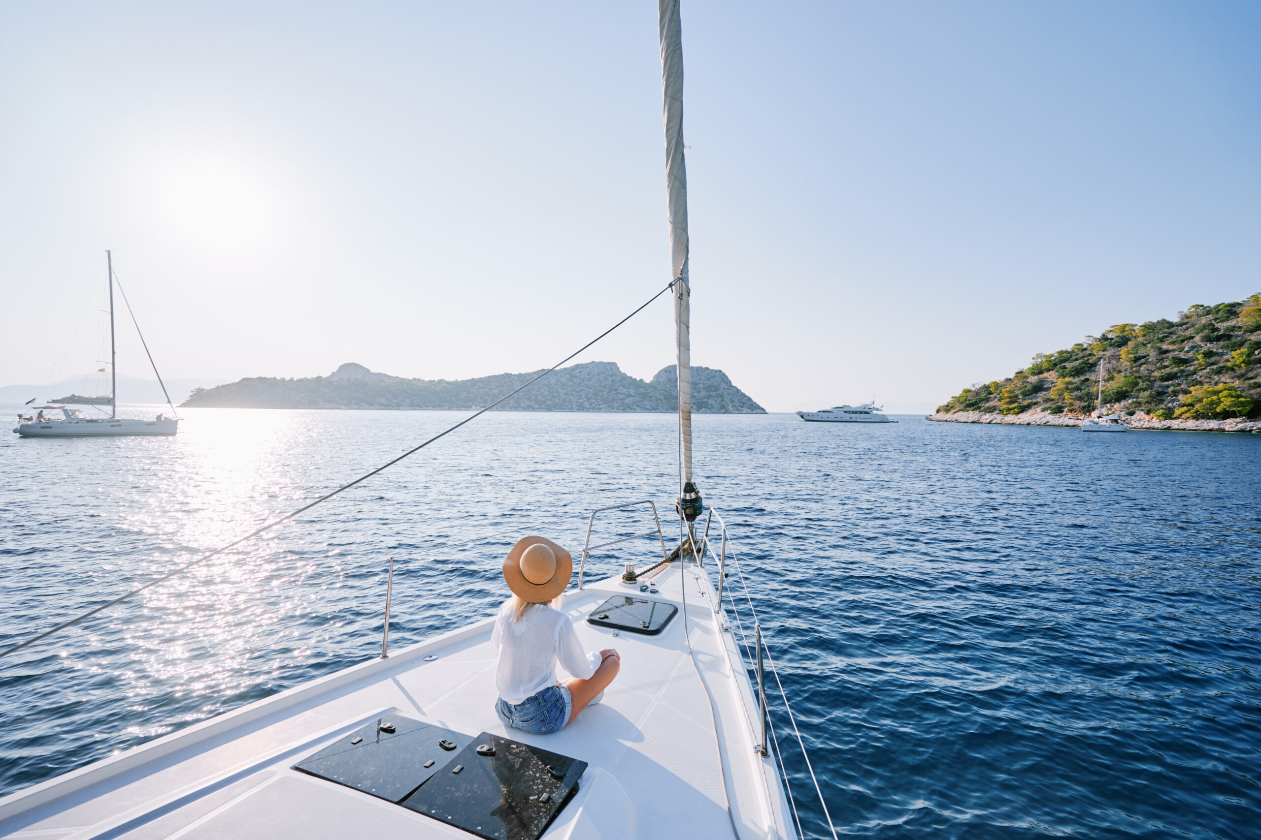 Woman leisurely cruising on a sailboat 